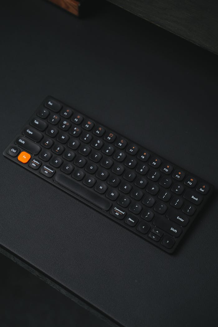 The Art of Drawing Readers In: Your attractive post title goes here Sleek black wireless keyboard with orange button on a dark background, perfect for tech setups.