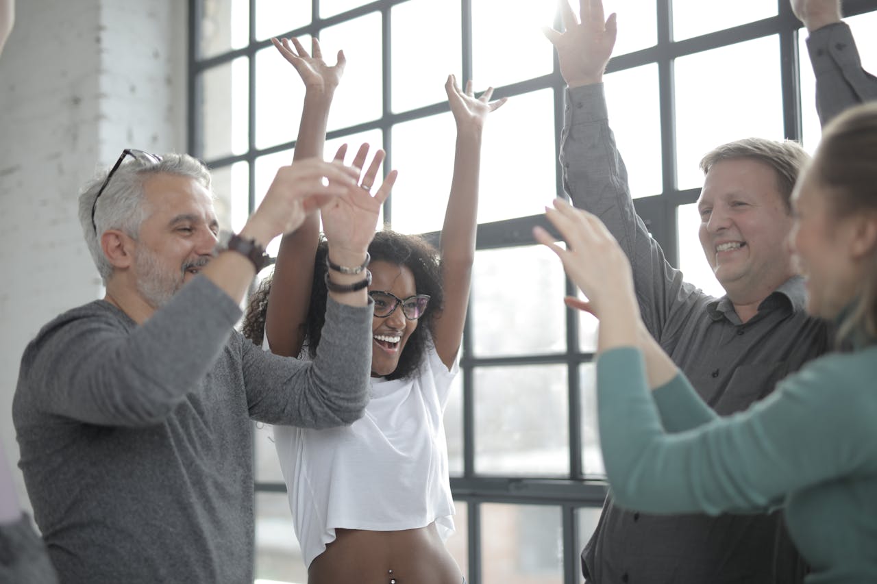 Crafting Captivating Headlines: Your awesome post title goes here Cheerful diverse coworkers in casual clothes raising hands while standing in circle near fenced window in afternoon and looking at each other