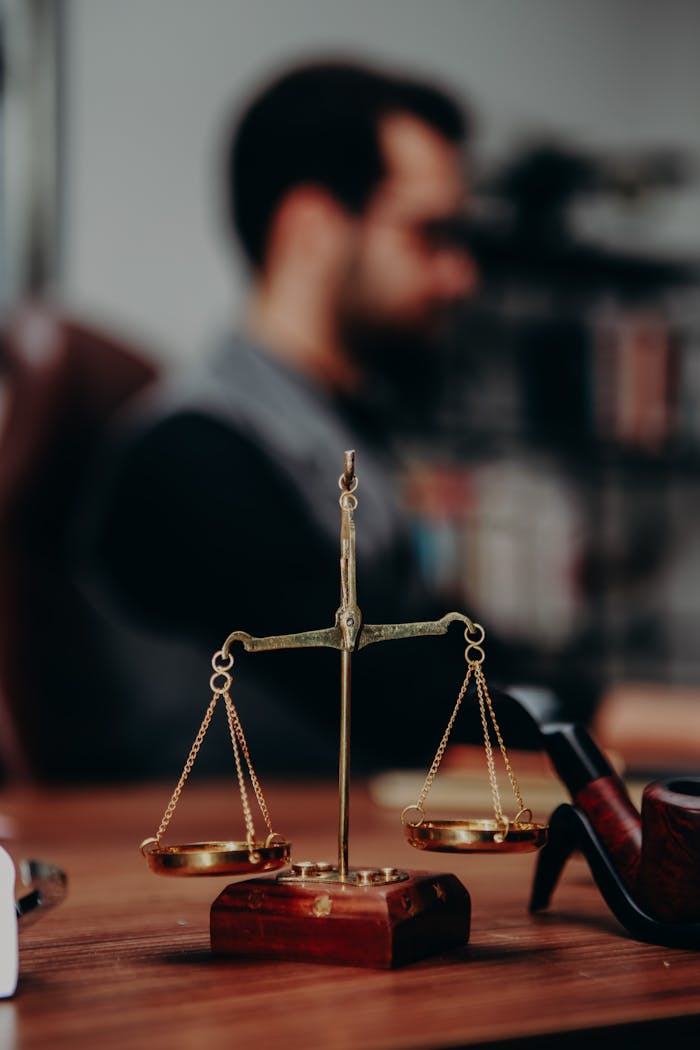 our-experience Close-up of justice scales and pipe on a lawyer's desk, emphasizing legal themes.